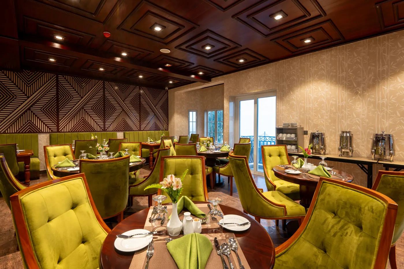 Chartreuse velvet dining chairs beneath a coffered ceiling