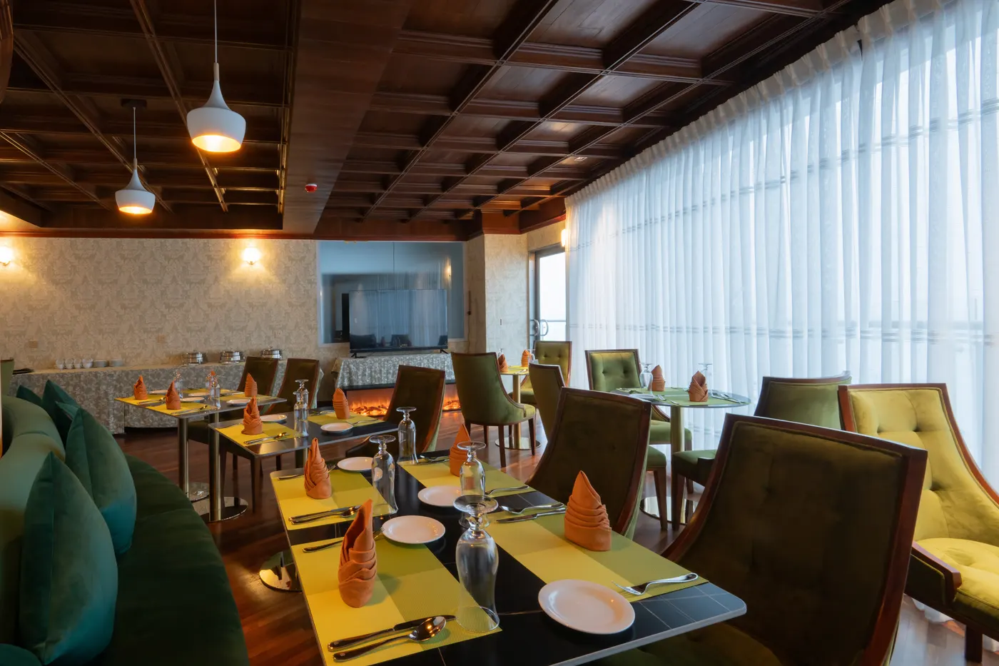 Bright dining room with green upholstery and highland windows