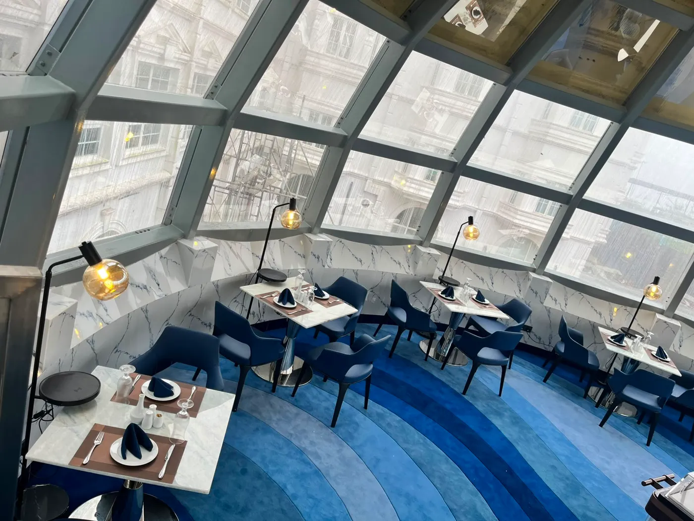 The Eye from above, glass panels sweeping down to the dining floor