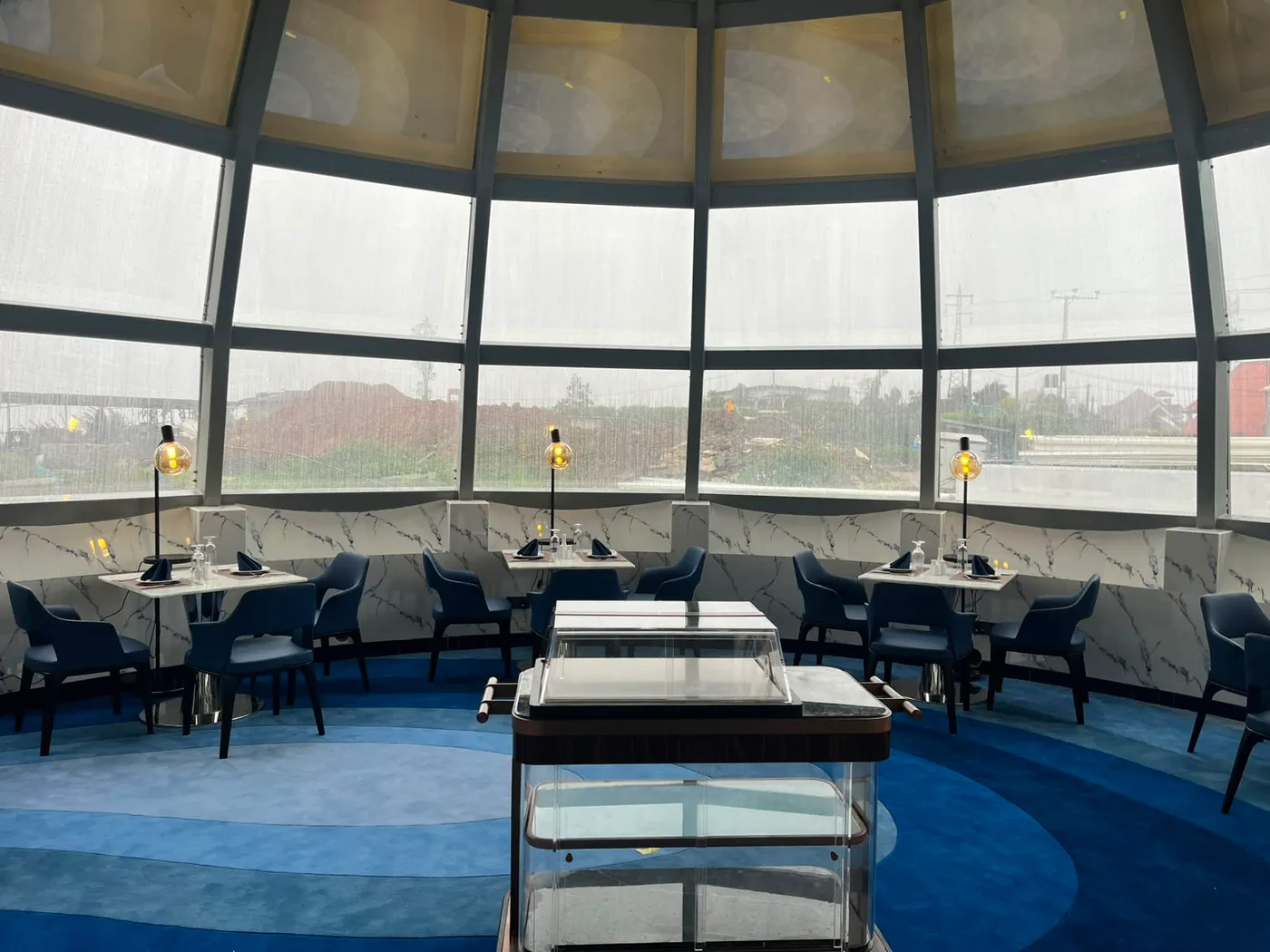The glass dome of The Eye curving over tables set for breakfast