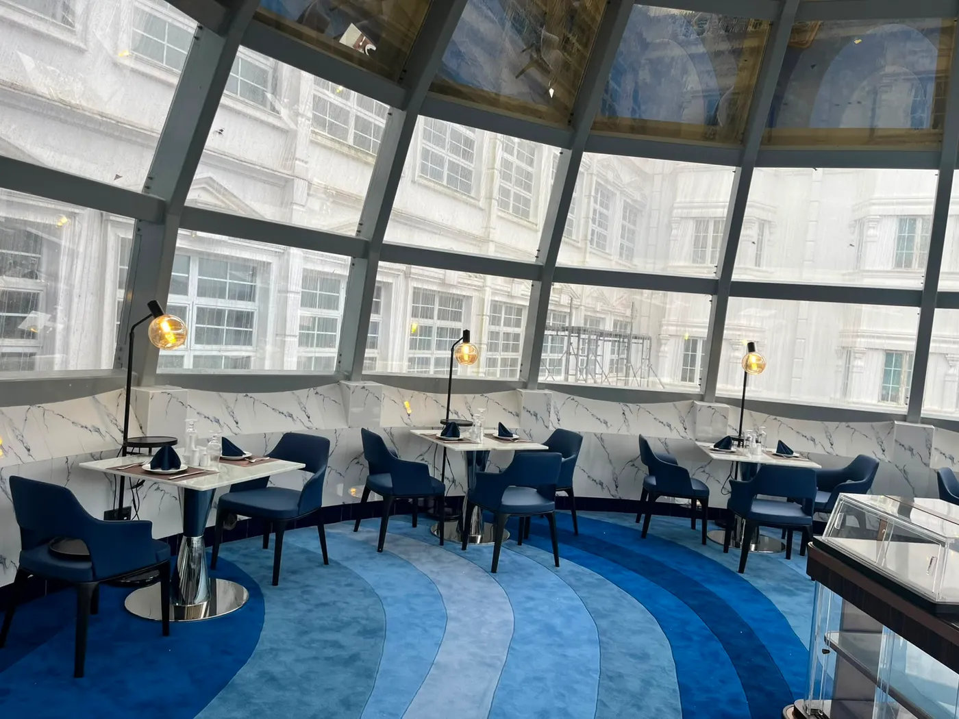 The curved marble banquette of The Eye beneath panes of dome glass
