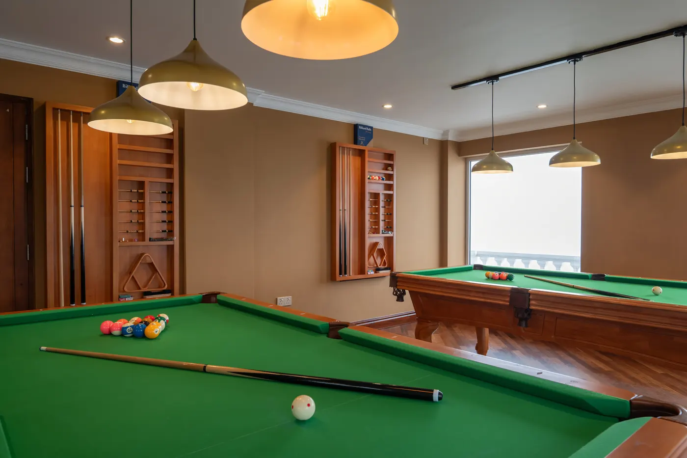 Pool table framed by brass pendant lights