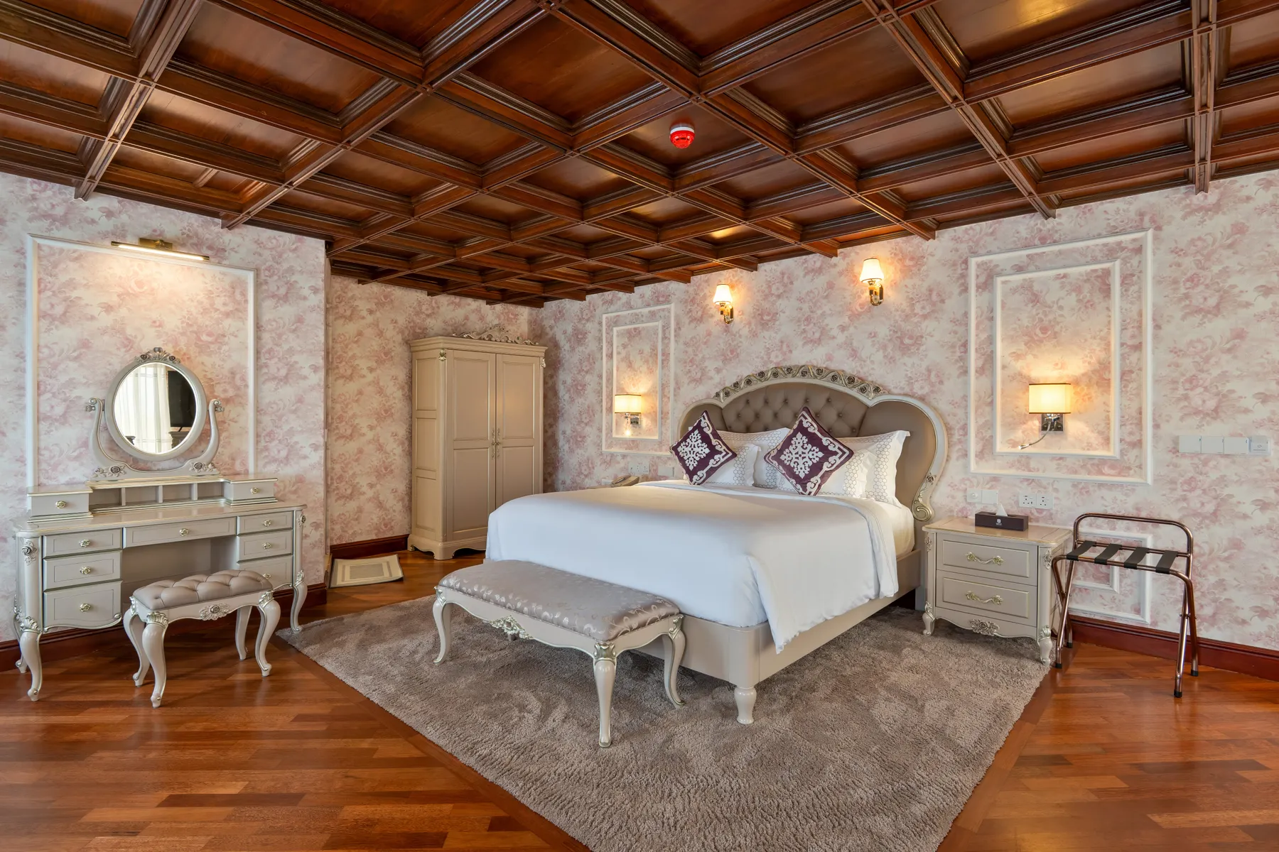 The Diplomatic Suite at Horton Heights, rose-patterned walls beneath a coffered timber ceiling